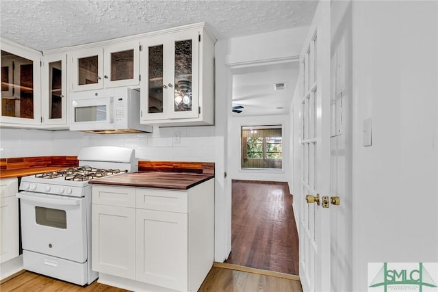 819 W 51st St, Savannah, GA 31405 - kitchen featuring white appliances, wooden counters, backsplash, glass insert cabinets, and a textured ceiling