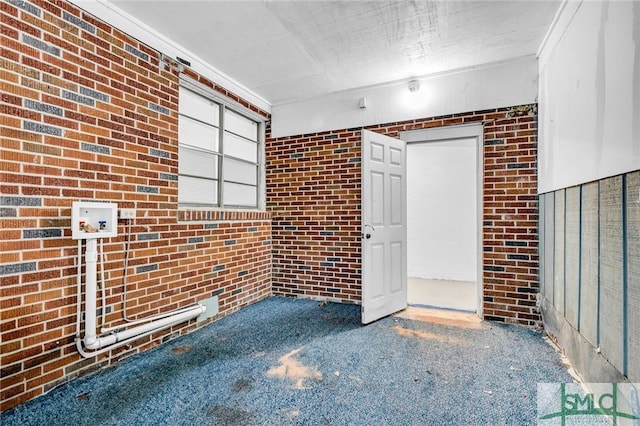 819 W 51st St, Savannah, GA 31405 - unfurnished living room featuring brick wall and carpet flooring