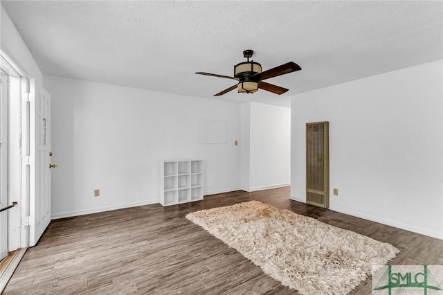 819 W 51st St, Savannah, GA 31405 - unfurnished living room featuring a heating unit, wood finished floors, a ceiling fan, a textured ceiling, and baseboards