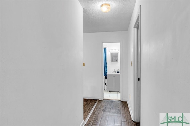 819 W 51st St, Savannah, GA 31405 - corridor featuring wood finished floors, a textured ceiling, a sink, and baseboards