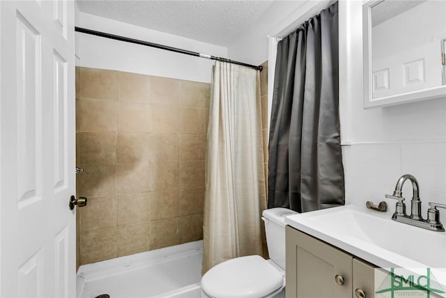 819 W 51st St, Savannah, GA 31405 - bathroom featuring toilet, a textured ceiling, vanity, tiled shower, and tile walls