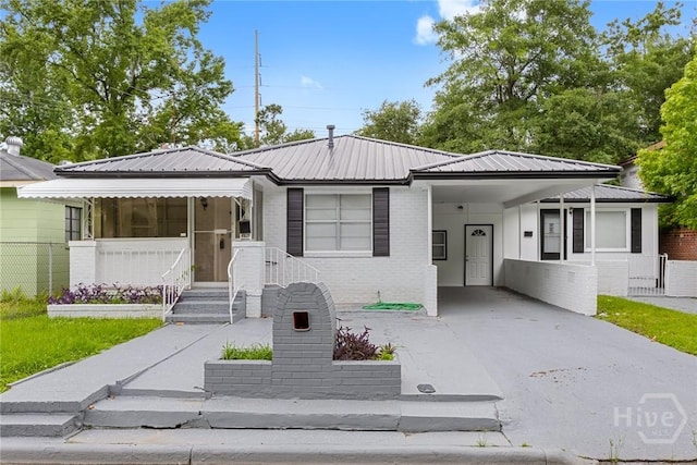 819 W 51st St, Savannah, GA 31405 - view of front of house featuring a carport, brick siding, driveway, and metal roof
