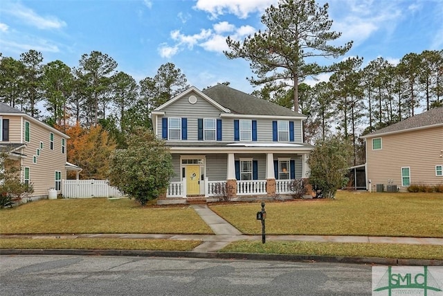colonial-style house with fence, a porch, and a front lawn