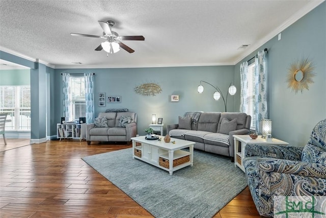 living room featuring ornamental molding, a textured ceiling, ceiling fan, and wood finished floors