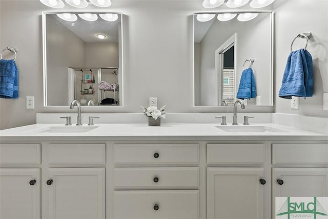 bathroom with double vanity, a sink, and a stall shower