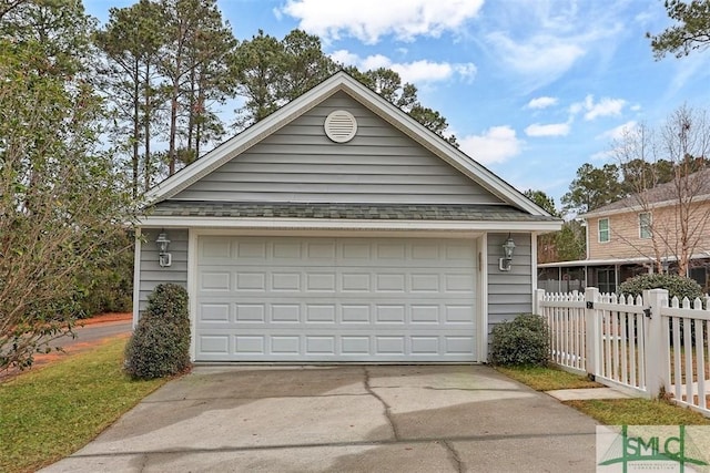 garage with fence and driveway