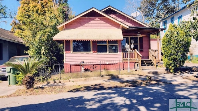bungalow with a porch and a fenced front yard