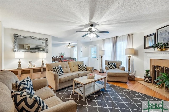 2504 Quacco Rd, Pooler, GA 31322 - living area featuring wood finished floors, a fireplace, baseboards, ceiling fan, and a textured ceiling