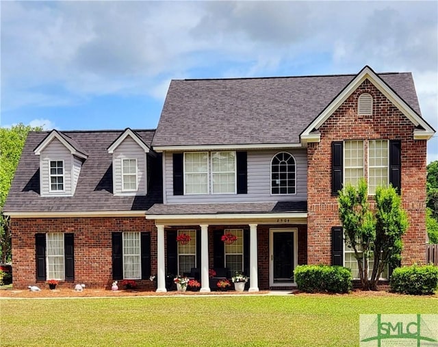 2504 Quacco Rd, Pooler, GA 31322 - traditional-style home with brick siding, a front yard, and a porch