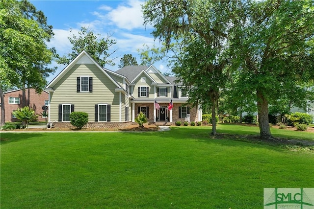 view of front of home with brick siding, covered porch, and a front yard