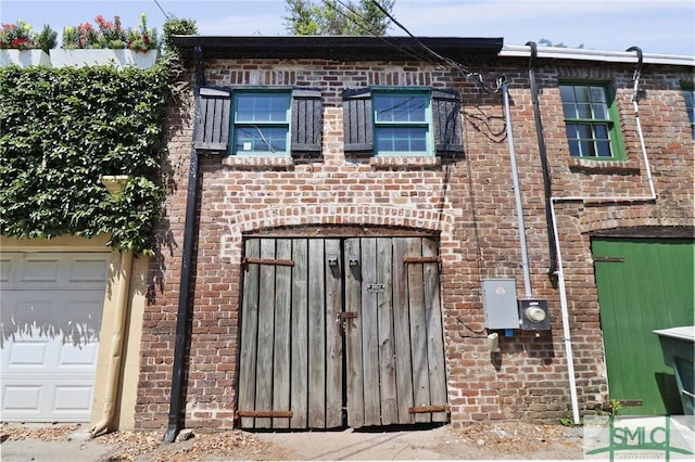 view of side of property with a gate and brick siding