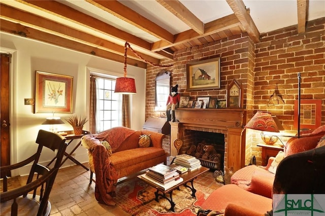 living area with beamed ceiling, a fireplace, brick wall, and brick floor
