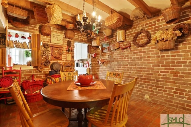 dining space featuring beamed ceiling, a notable chandelier, brick wall, and brick floor