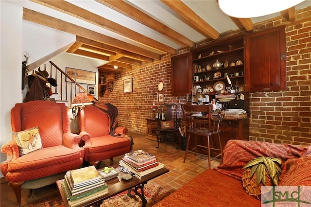 living area featuring brick wall, stairs, and brick floor