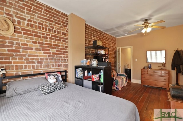 bedroom featuring brick wall, ceiling fan, baseboards, and hardwood / wood-style floors