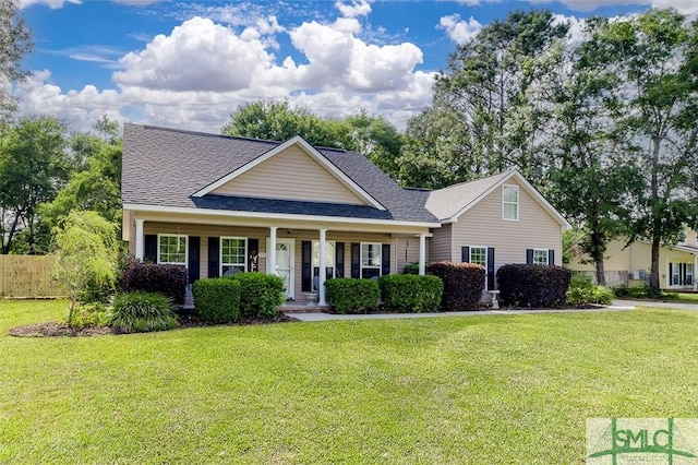213 Rosehill Dr E, Rincon, GA 31326 - view of front of house featuring a front yard, roof with shingles, covered porch, and fence