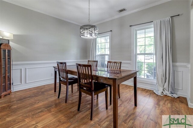213 Rosehill Dr E, Rincon, GA 31326 - dining area with an inviting chandelier, a decorative wall, crown molding, a wainscoted wall, and wood finished floors