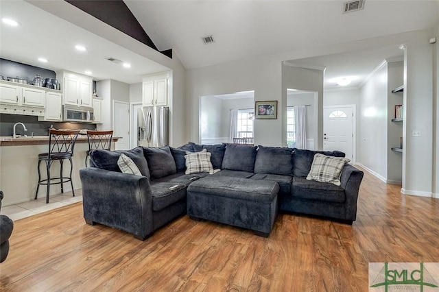 213 Rosehill Dr E, Rincon, GA 31326 - living area with vaulted ceiling, ornamental molding, visible vents, and light wood-style floors