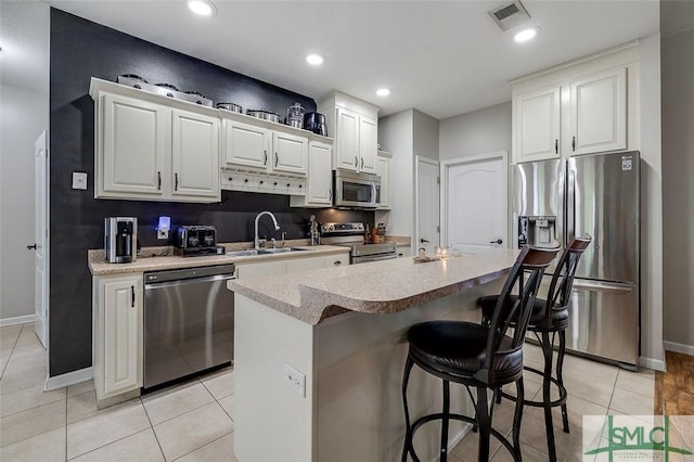 213 Rosehill Dr E, Rincon, GA 31326 - kitchen with a center island, visible vents, a sink, a kitchen breakfast bar, and appliances with stainless steel finishes