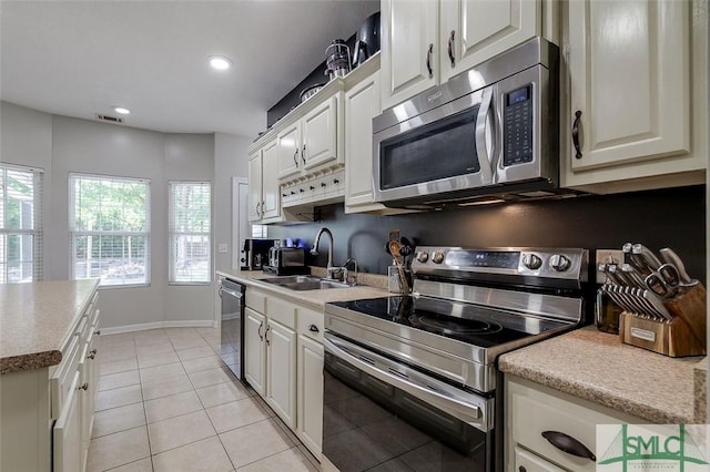 213 Rosehill Dr E, Rincon, GA 31326 - kitchen with light tile patterned floors, visible vents, a sink, white cabinetry, and stainless steel appliances