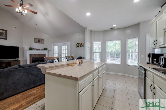 213 Rosehill Dr E, Rincon, GA 31326 - kitchen with visible vents, a fireplace, a ceiling fan, light tile patterned floors, and stainless steel dishwasher