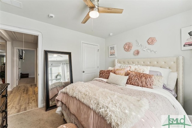 bedroom featuring ceiling fan, light carpet, and attic access