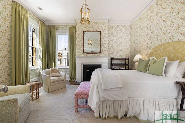 bedroom with wallpapered walls, visible vents, a fireplace, and crown molding