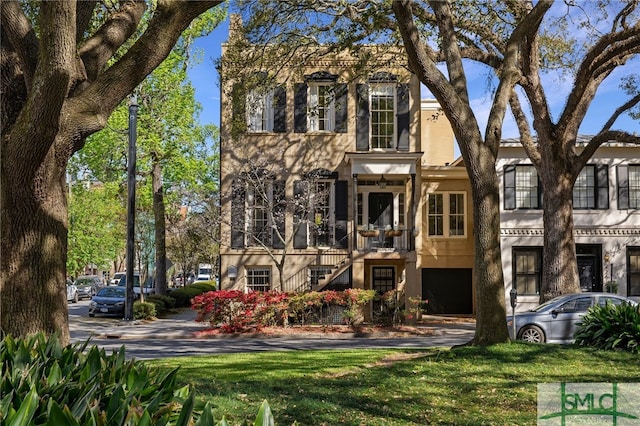 view of front of home with stairway and stucco siding