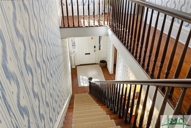 stairs featuring a wealth of natural light and wood finished floors