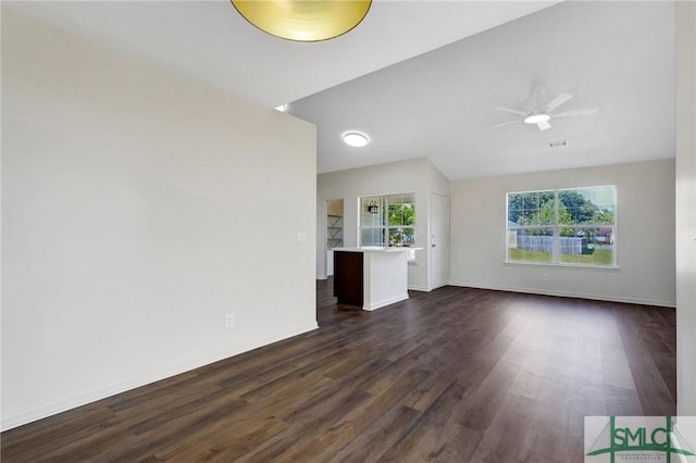 unfurnished living room with lofted ceiling, baseboards, dark wood finished floors, ceiling fan, and visible vents