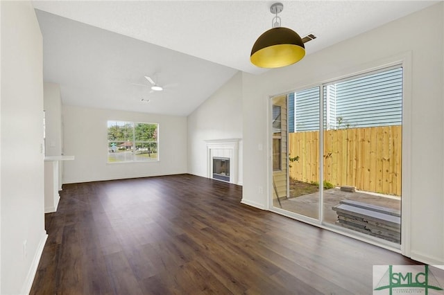 unfurnished living room with wood finished floors, a ceiling fan, a fireplace, visible vents, and vaulted ceiling