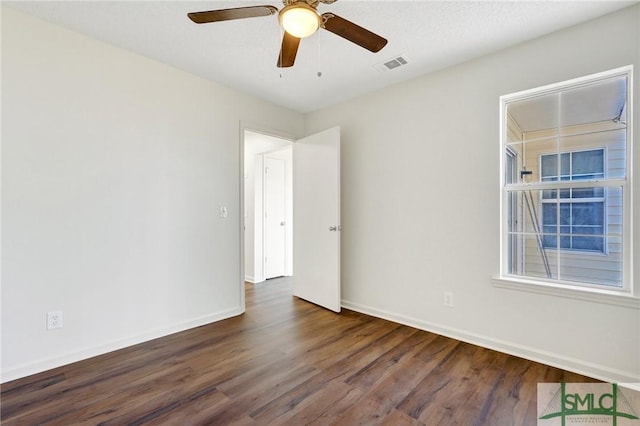 unfurnished room with ceiling fan, baseboards, visible vents, and wood finished floors