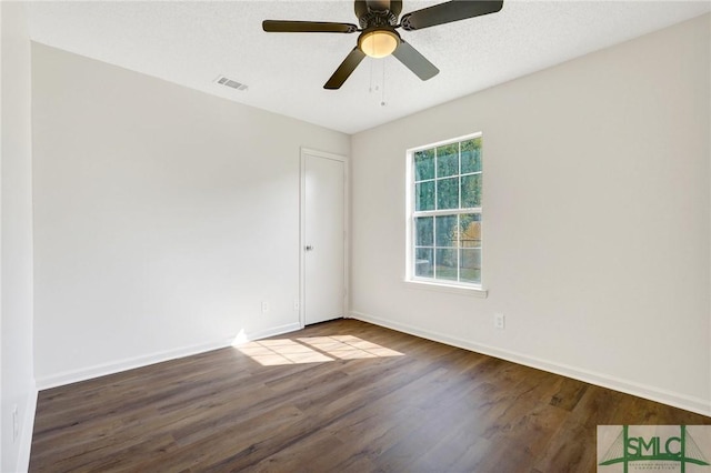 spare room featuring a ceiling fan, visible vents, wood finished floors, and baseboards