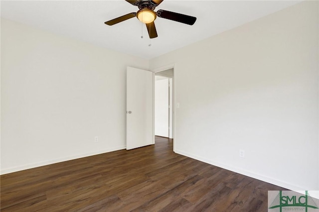 empty room featuring baseboards, dark wood-style floors, and a ceiling fan