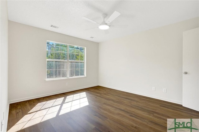 unfurnished room with ceiling fan, baseboards, visible vents, and wood finished floors