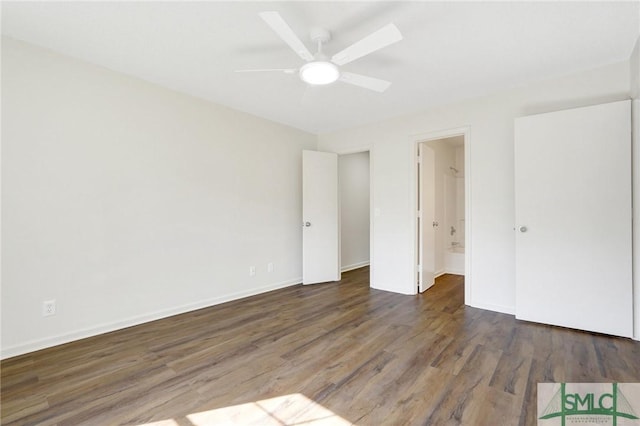 unfurnished bedroom featuring baseboards, ensuite bathroom, and wood finished floors