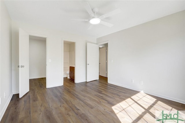 unfurnished bedroom with connected bathroom, baseboards, ceiling fan, and dark wood-style floors