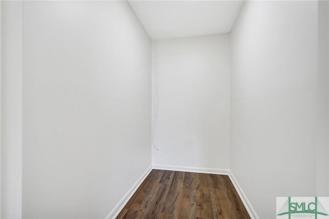 unfurnished room featuring baseboards and dark wood finished floors