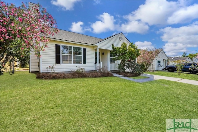 ranch-style home featuring covered porch and a front lawn