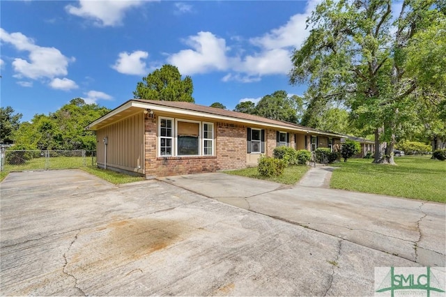 ranch-style house with fence, driveway, brick siding, and a front yard