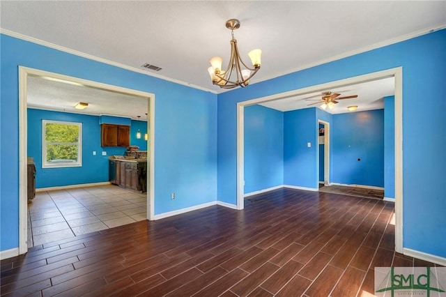 unfurnished room featuring wood finished floors, baseboards, ceiling fan with notable chandelier, and ornamental molding