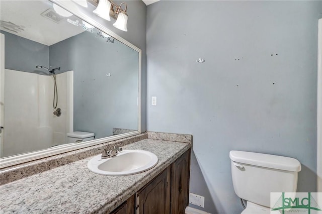 full bath featuring vanity, toilet, a shower, and visible vents