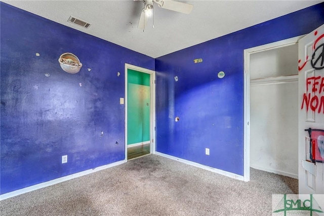 unfurnished bedroom featuring carpet, visible vents, baseboards, and a ceiling fan