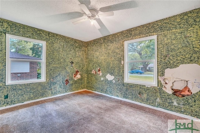 unfurnished room with a textured ceiling, ceiling fan, and carpet floors