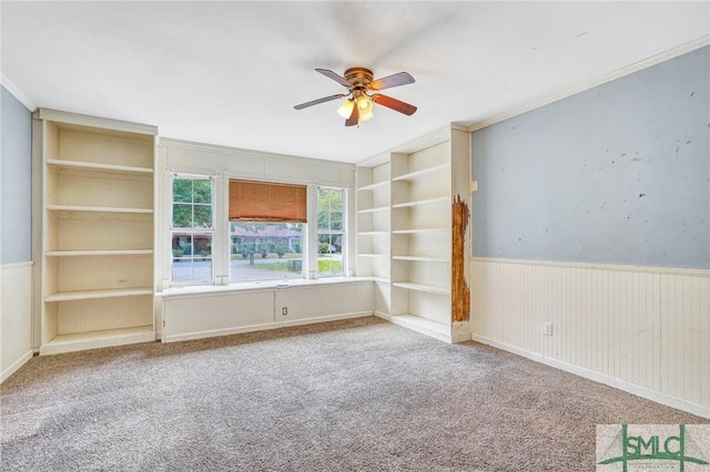unfurnished room featuring a ceiling fan, crown molding, and carpet floors