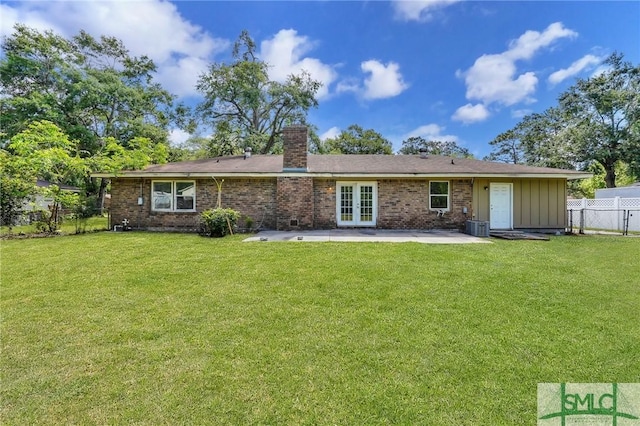 rear view of property featuring a yard, a patio, french doors, and a chimney
