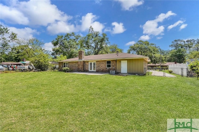 back of house featuring a yard, fence, french doors, and a chimney