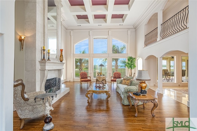 interior space with coffered ceiling, arched walkways, a healthy amount of sunlight, and beam ceiling
