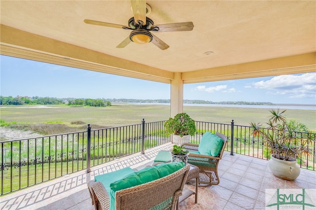 view of patio with a ceiling fan, a rural view, and an outdoor living space