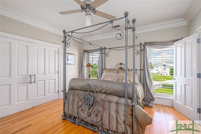 bedroom with crown molding, visible vents, and light wood-style floors